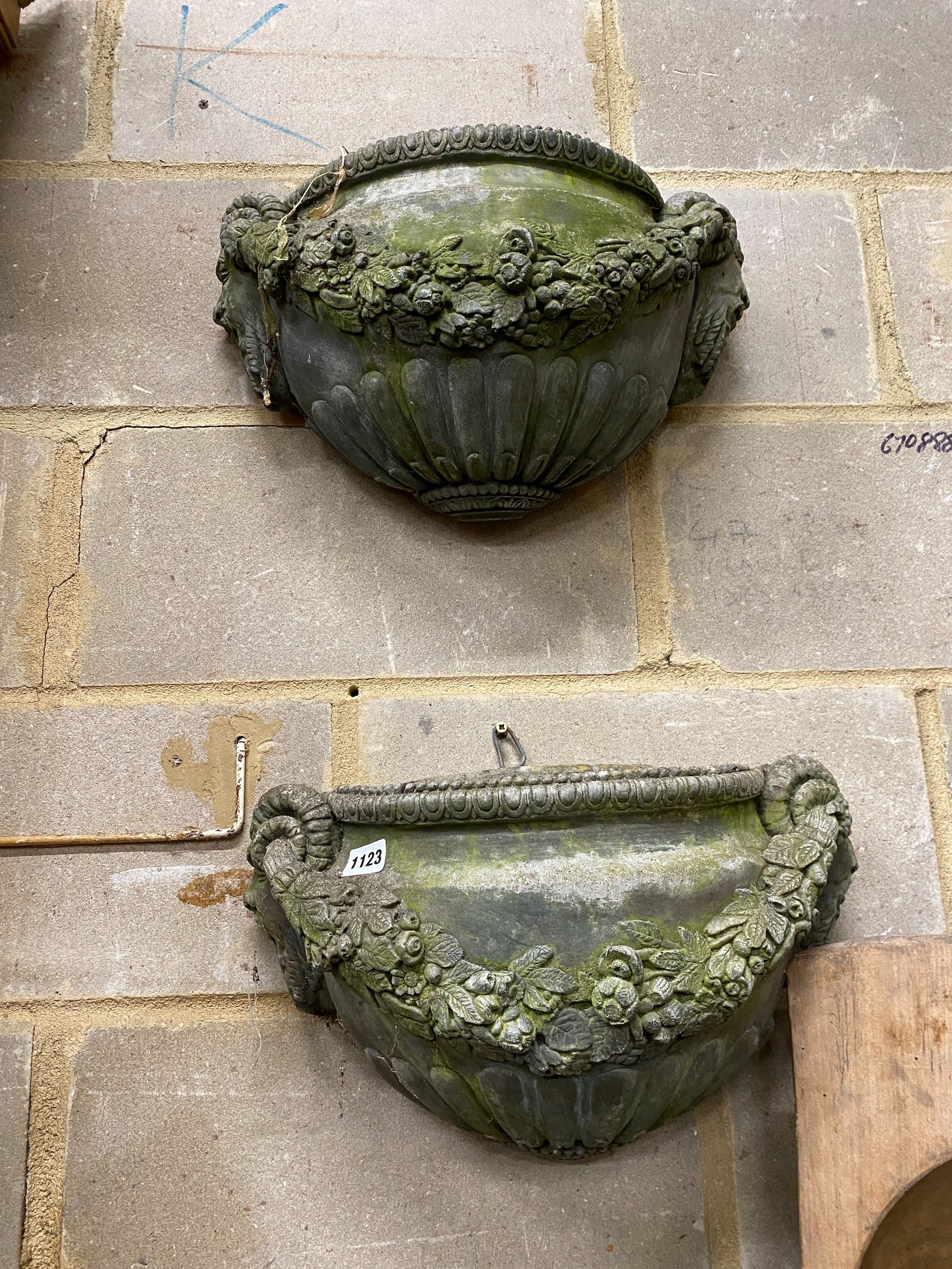 A pair of reconstituted stone garden wall planters, width 45cm, height 24cm